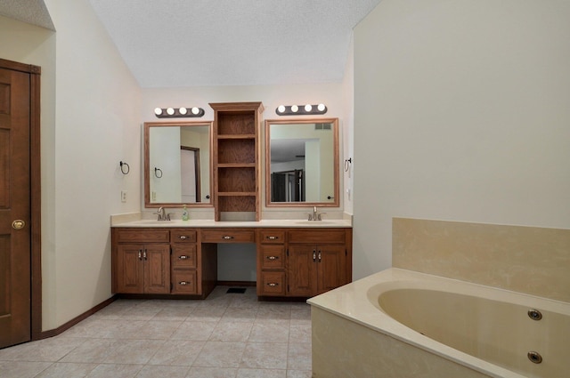 bathroom with vanity, a bathtub, and a textured ceiling