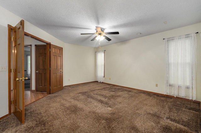 empty room featuring ceiling fan, carpet flooring, and a textured ceiling