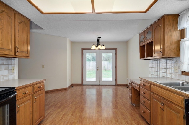 kitchen featuring tasteful backsplash, pendant lighting, light hardwood / wood-style flooring, and a textured ceiling