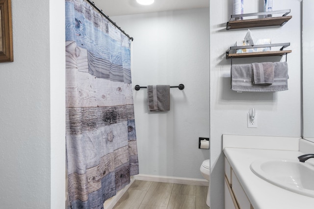 123 Bunker Ridge Dr Unit 7, Branson, MO 65616 - full bathroom with wood finished floors, toilet, vanity, baseboards, and a shower with shower curtain