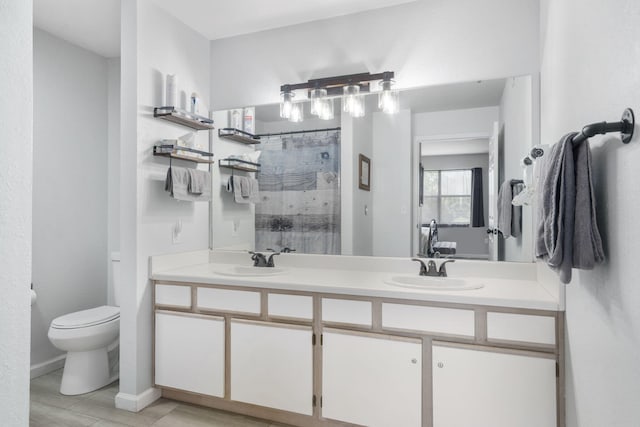 bathroom with vanity, toilet, and curtained shower