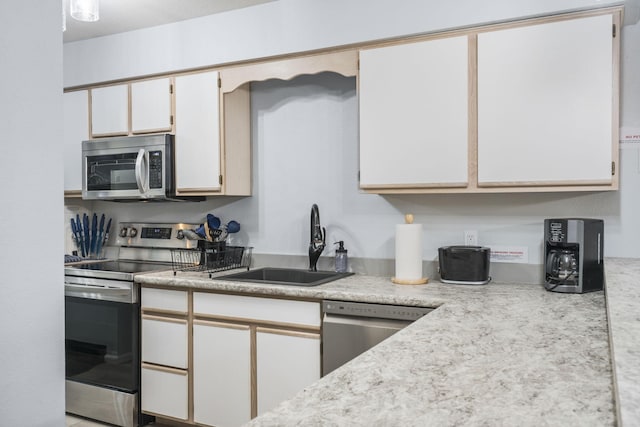 123 Bunker Ridge Dr Unit 7, Branson, MO 65616 - kitchen featuring appliances with stainless steel finishes, a sink, white cabinetry, and light countertops