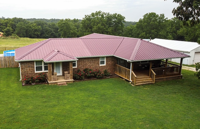 view of front of home with a front yard and a wooden deck