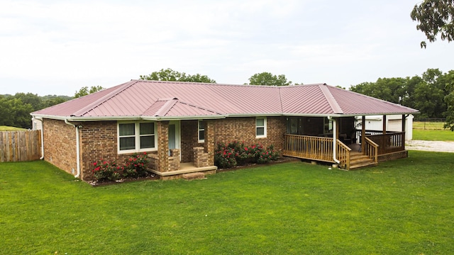 view of front of house with a wooden deck and a front lawn