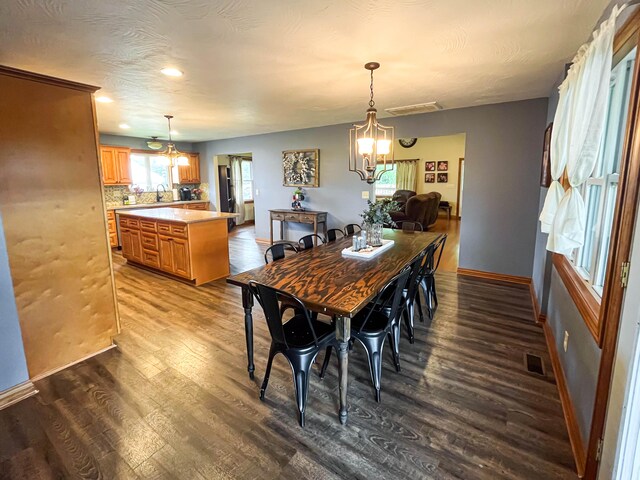 dining area with hardwood / wood-style flooring, a notable chandelier, and sink