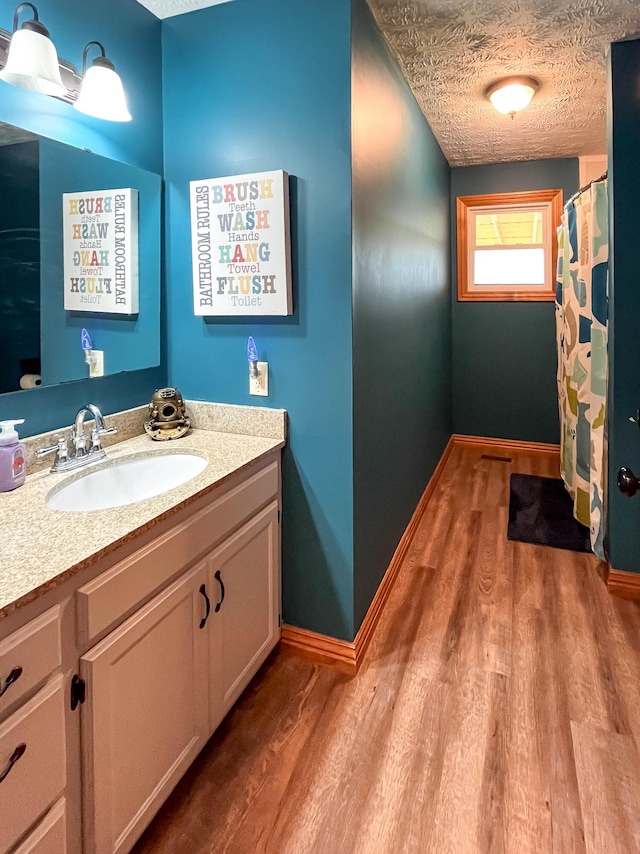 bathroom featuring hardwood / wood-style flooring, vanity, and a textured ceiling