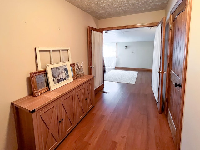 hallway featuring a textured ceiling and light wood-type flooring