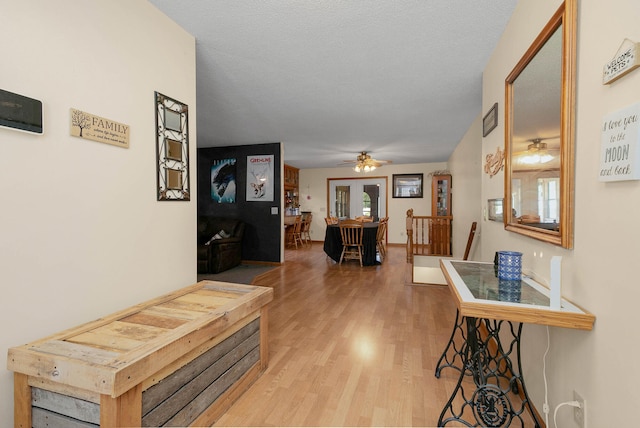 hall featuring light hardwood / wood-style flooring and a textured ceiling