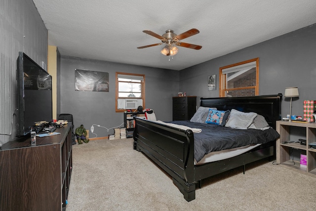 bedroom with ceiling fan, light colored carpet, a textured ceiling, and cooling unit