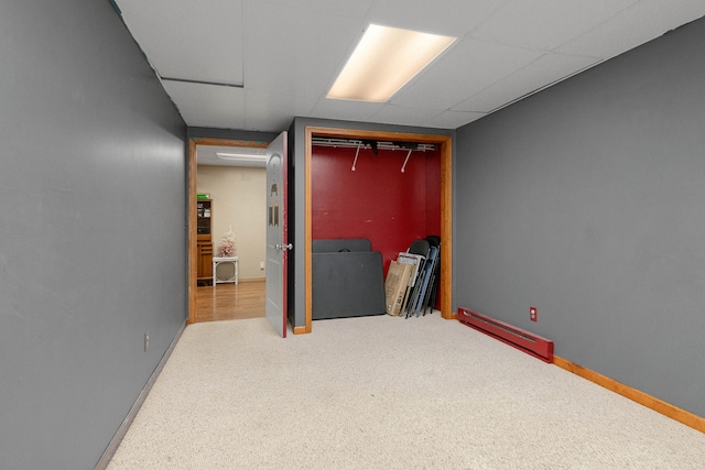 interior space featuring baseboard heating and a drop ceiling