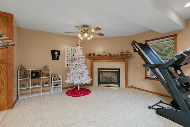 exercise area featuring a fireplace, carpet flooring, and ceiling fan