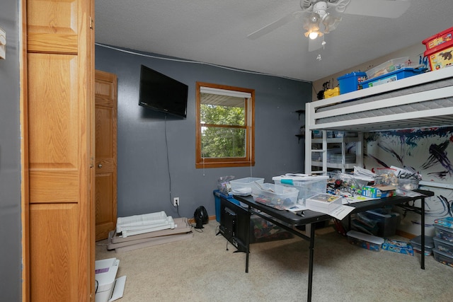 carpeted bedroom featuring ceiling fan and a textured ceiling