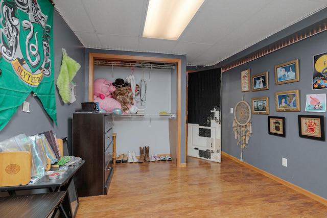 miscellaneous room featuring a drop ceiling and hardwood / wood-style flooring