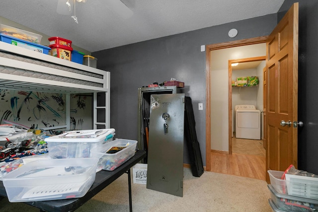 bedroom with light wood-type flooring, washer / dryer, ceiling fan, and a textured ceiling