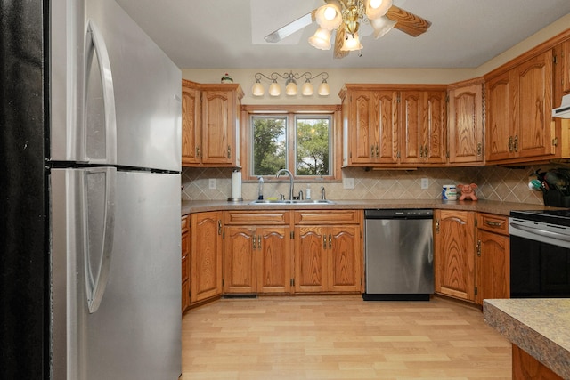 kitchen with backsplash, light hardwood / wood-style floors, appliances with stainless steel finishes, and sink