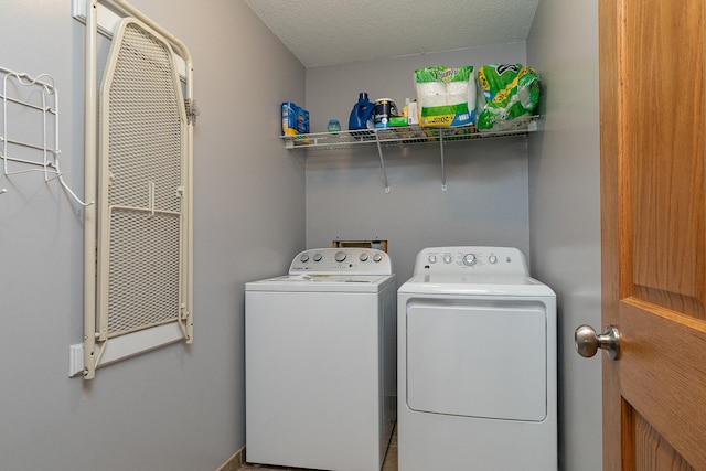 clothes washing area with independent washer and dryer and a textured ceiling