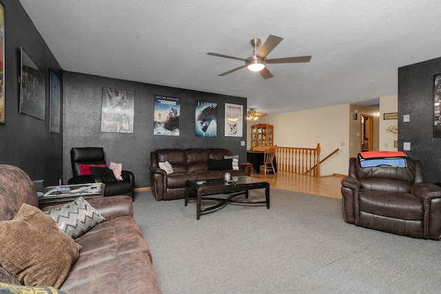 carpeted living room with a textured ceiling and ceiling fan