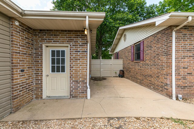 view of exterior entry with a patio area