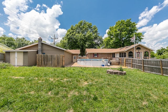 exterior space featuring a fenced in pool, a lawn, and a shed