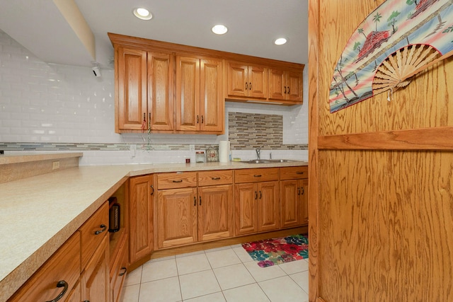 kitchen featuring light tile patterned flooring, sink, and decorative backsplash