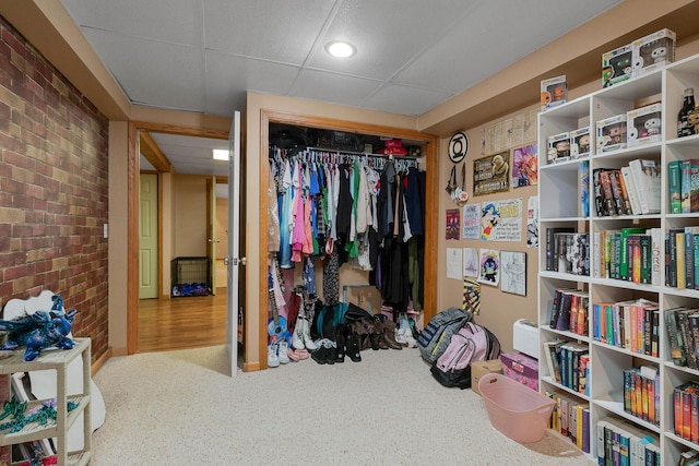 interior space with wood-type flooring, a closet, and brick wall