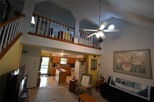 living room featuring ceiling fan and high vaulted ceiling