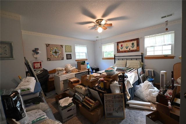 carpeted bedroom featuring crown molding, ceiling fan, and a textured ceiling