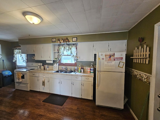 kitchen featuring white appliances, a wealth of natural light, and white cabinetry