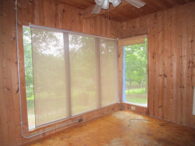 unfurnished sunroom featuring ceiling fan and a healthy amount of sunlight