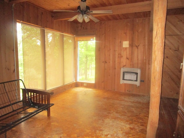 interior space with wood ceiling, heating unit, wooden walls, and ceiling fan