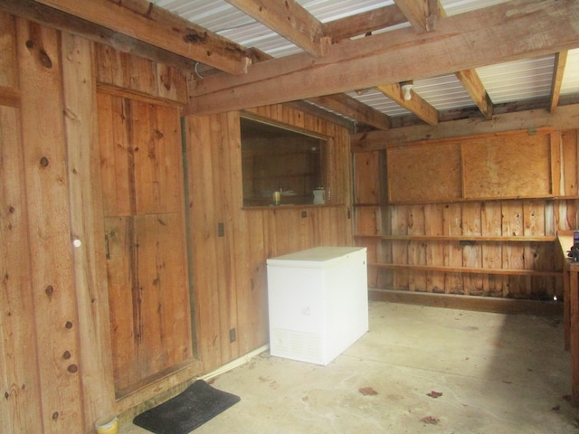 interior space featuring wooden walls and beam ceiling