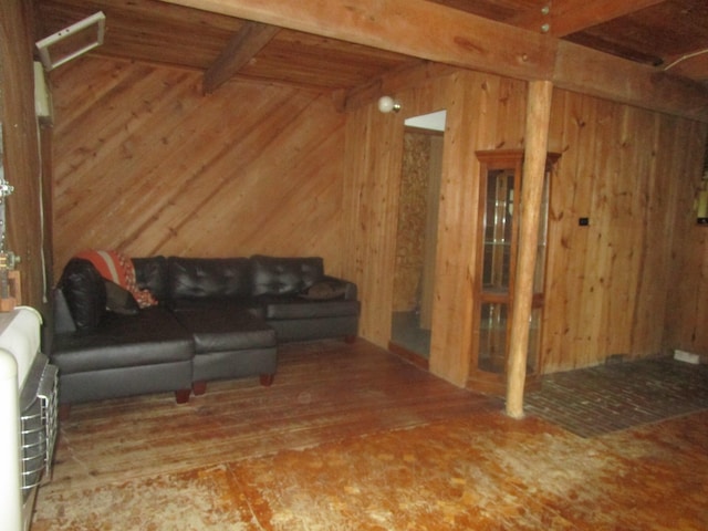 living room featuring beam ceiling and wood walls