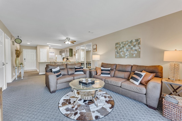 carpeted living room with baseboards and ceiling fan