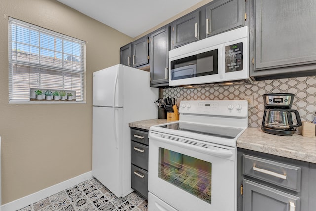 kitchen with light countertops, baseboards, decorative backsplash, and white appliances