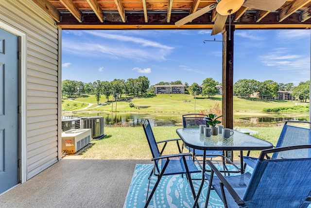 view of patio featuring central air condition unit, golf course view, outdoor dining area, and a water view