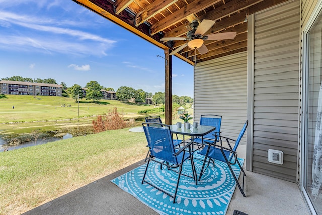 view of patio featuring outdoor dining area, a water view, golf course view, and ceiling fan
