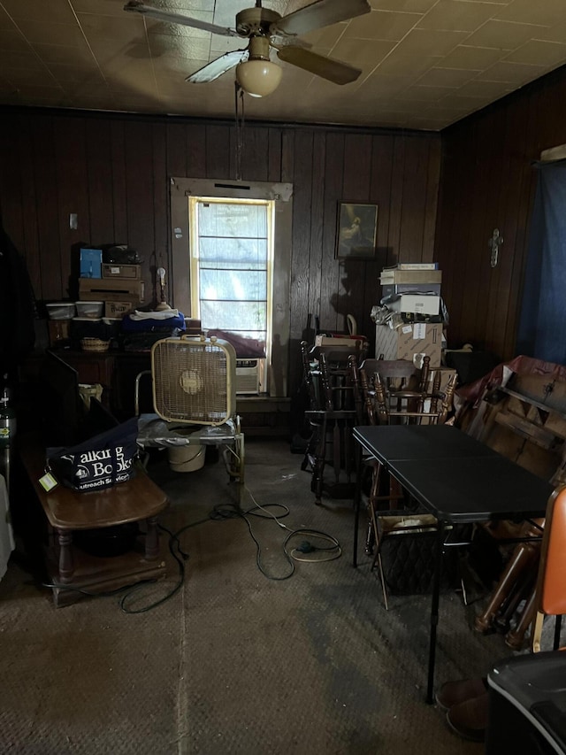 interior space featuring ceiling fan, carpet, and wood walls