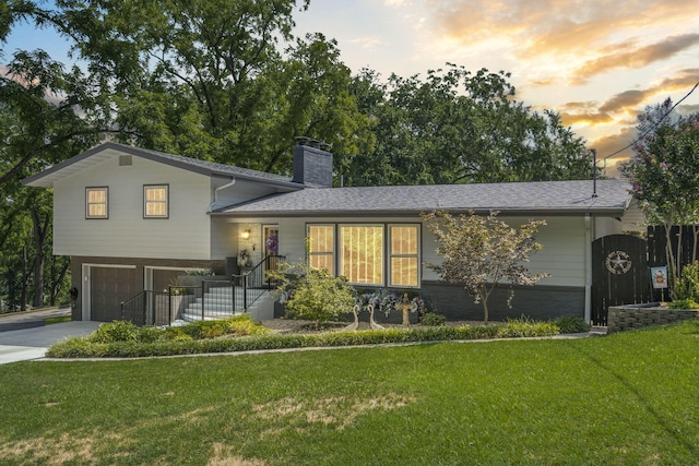 split level home with a lawn and a garage