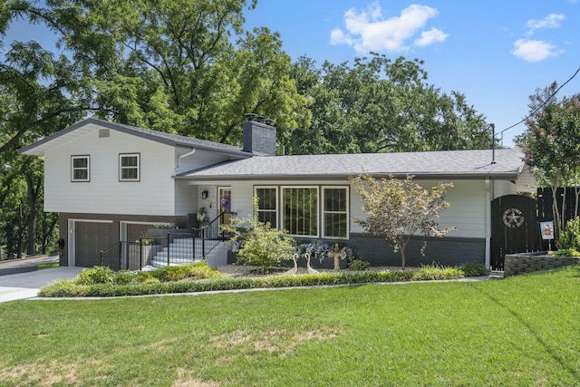 tri-level home featuring a garage and a front lawn