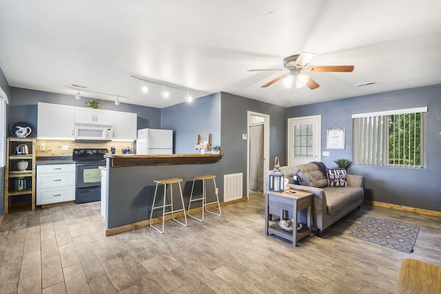 living room featuring ceiling fan, rail lighting, and light hardwood / wood-style floors