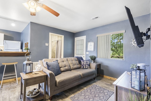 living room featuring hardwood / wood-style floors and ceiling fan