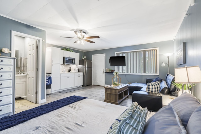 bedroom featuring connected bathroom, a ceiling fan, and freestanding refrigerator