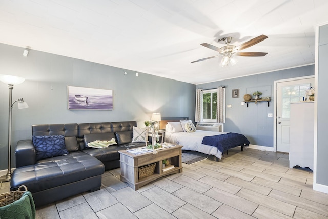 bedroom featuring wood finish floors, a ceiling fan, and baseboards