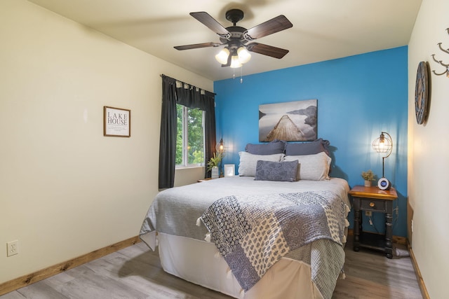 bedroom featuring wood finished floors, baseboards, and ceiling fan
