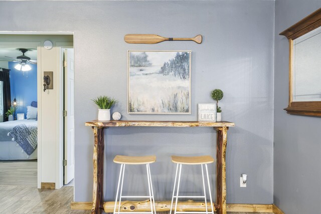 interior details with baseboards, wood finished floors, and ceiling fan