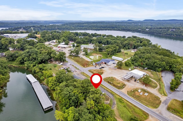 birds eye view of property featuring a forest view and a water view