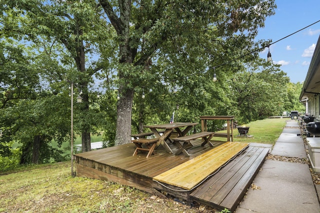 deck with outdoor dining area and a yard