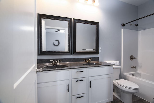 full bathroom featuring hardwood / wood-style floors, shower / washtub combination, vanity, and toilet