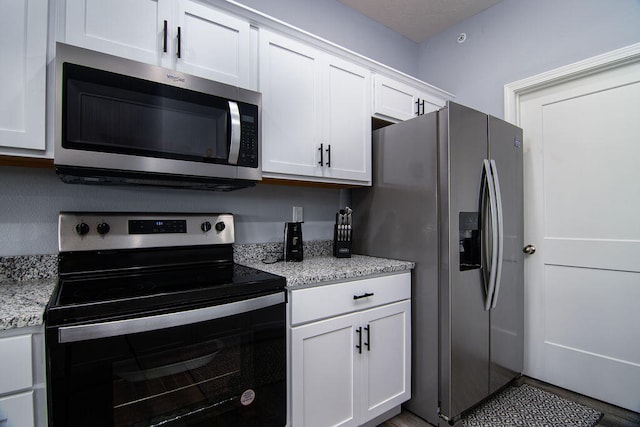 kitchen featuring light stone countertops, white cabinets, and appliances with stainless steel finishes