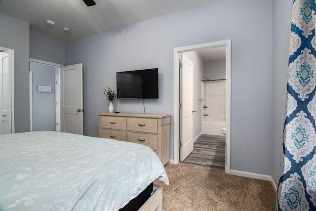 carpeted bedroom with ensuite bathroom and ceiling fan